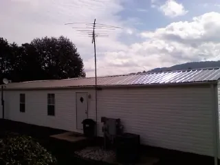 New metal roof on a single wide mobile home with a TV antenna in Lodge