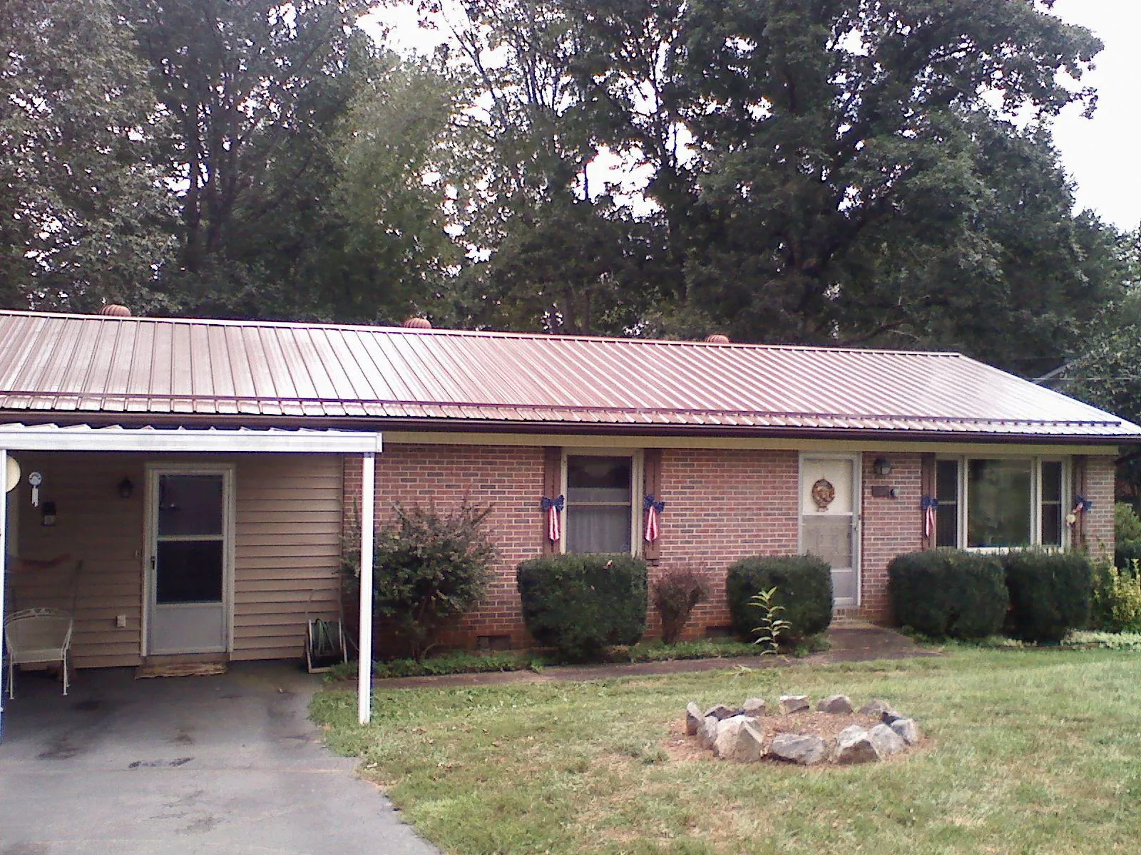 Bronze metal roof and carport on a brick ranch home — Roof Repair work by our crew in Lodge
